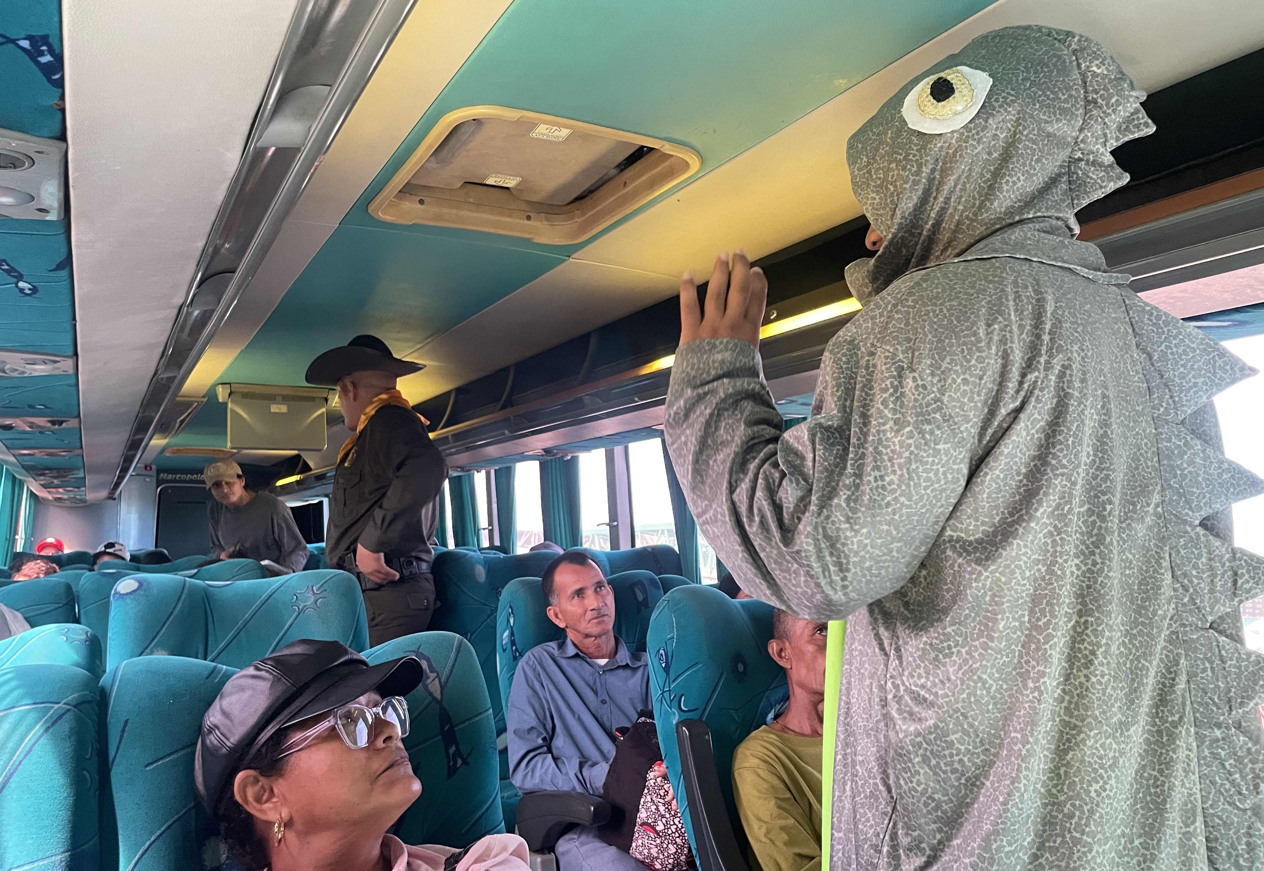 Funcionario disfrazado de iguana montado en bus con pasajeros