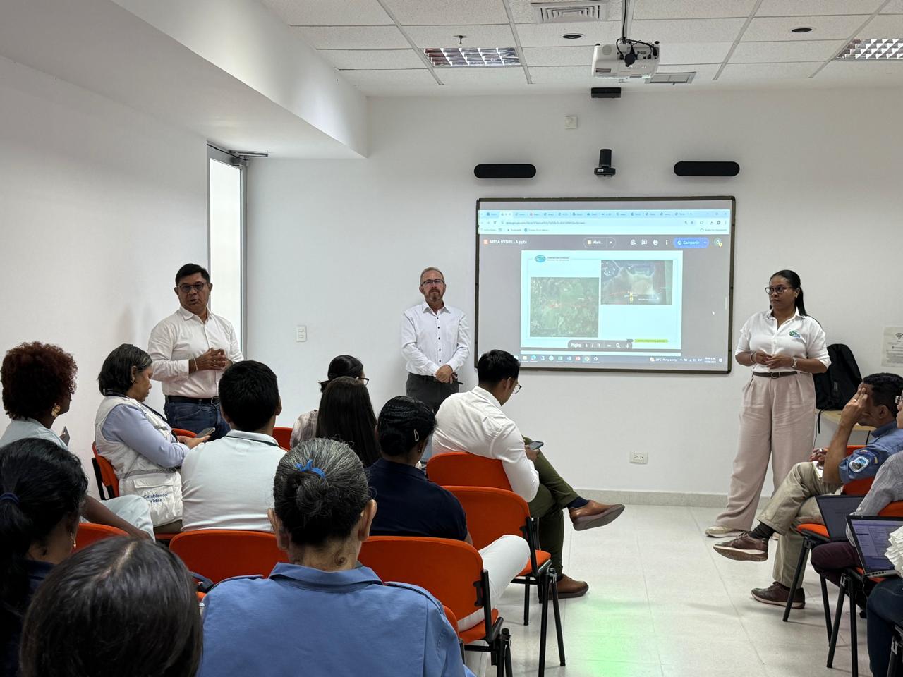 Foto panoramica de la reunion donde se observa a los asistentes y al Director de Corpamag hablando