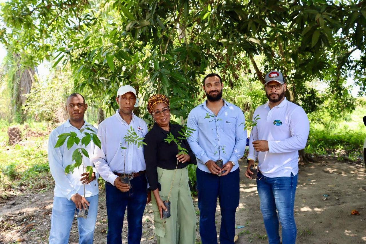 Foto grupal del personal de CORPAMAG y Fedepalma con duela del predio sosteniendo los arboles