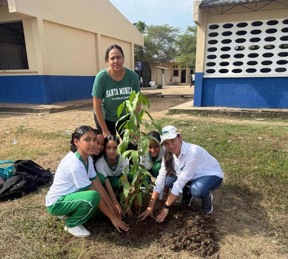 Funcionaria sembrando un arbol en salamina con comunidad