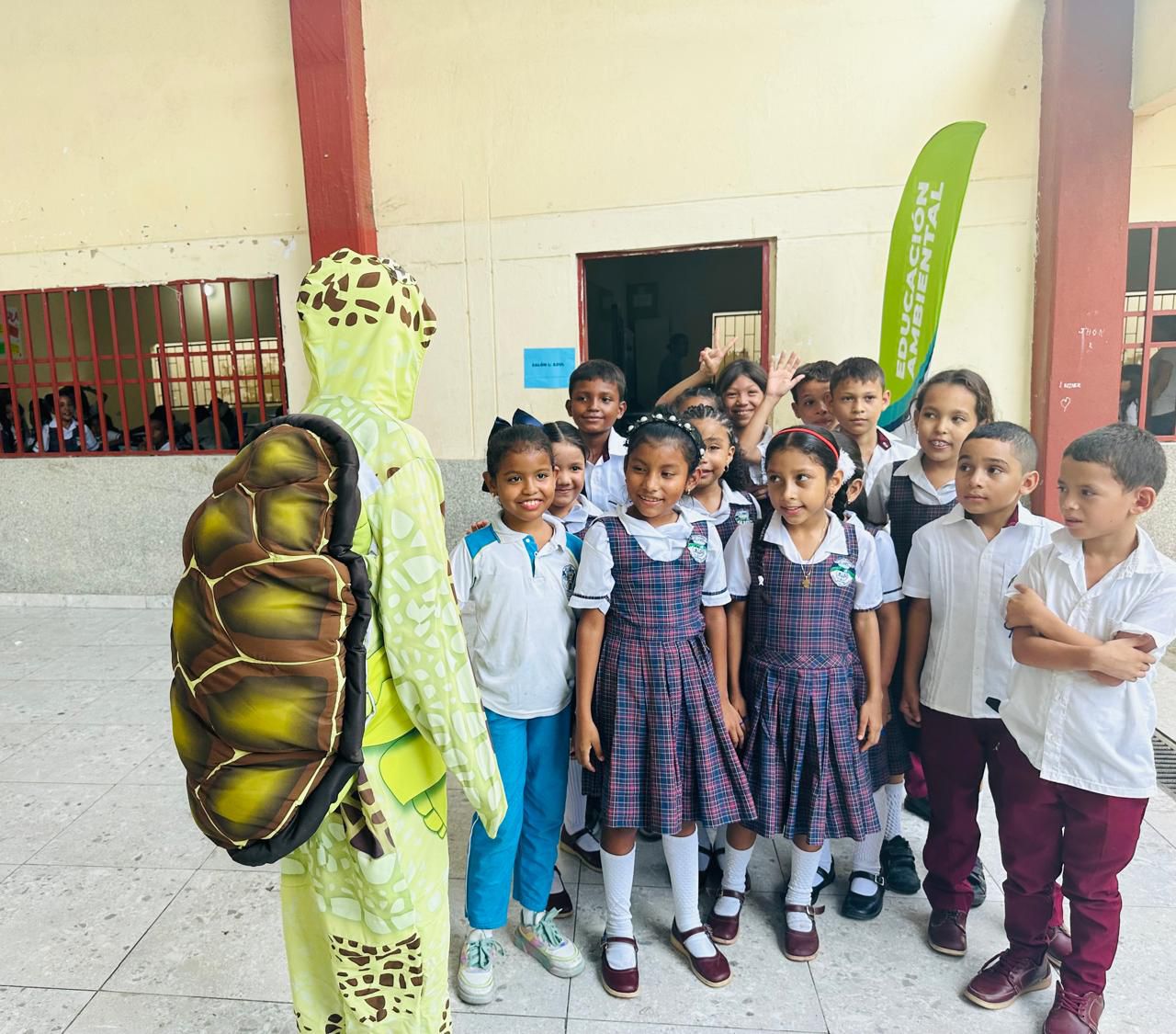Grupo de niños escuchando a personal de CORPAMAG usando un disfraz de trotuga