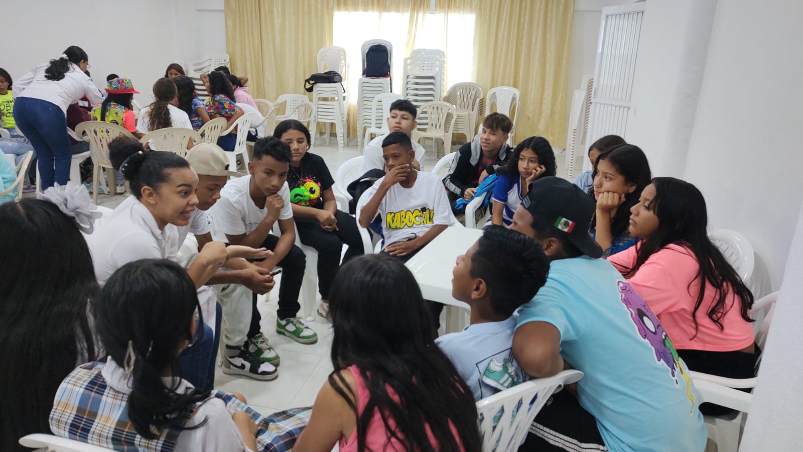 gRUPO DE JOVENES CON FUNCIONARIOS REUNIDOS EN MESA