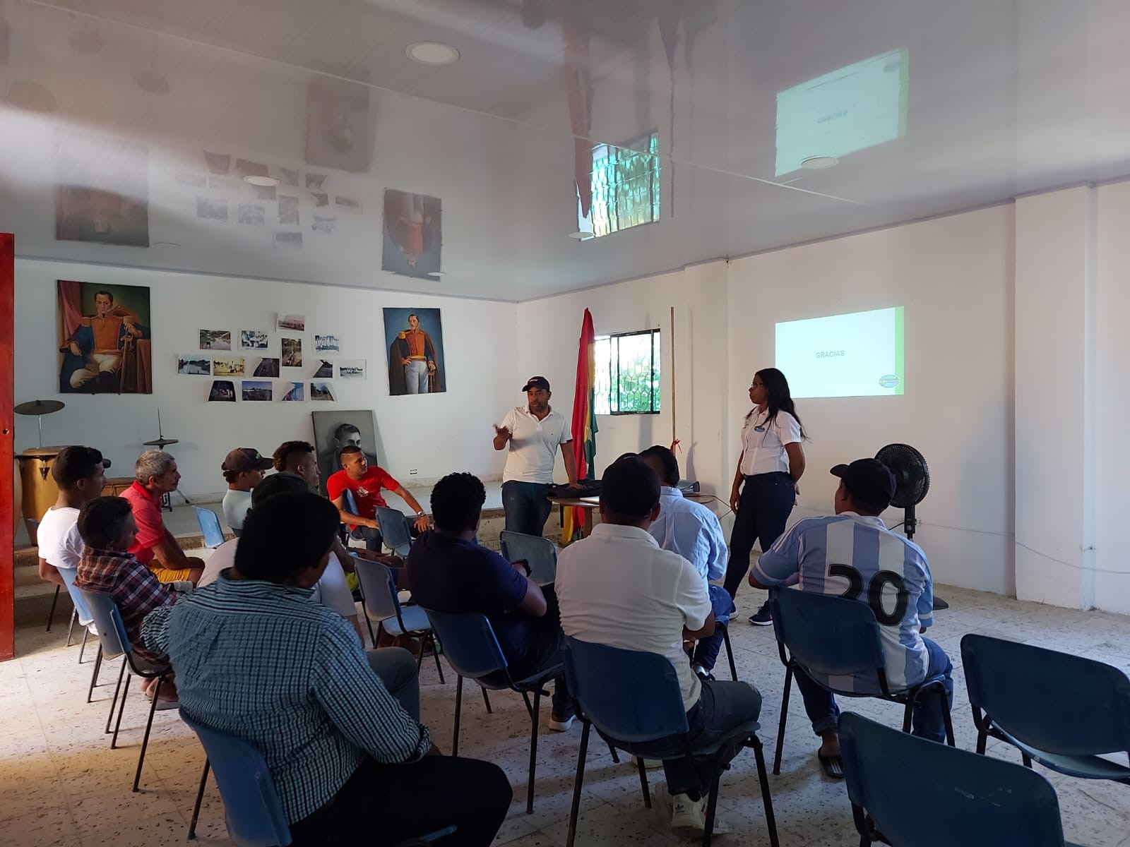 Grupo de personas reunidas en un salòn. Funcionario de Corpamag explicando