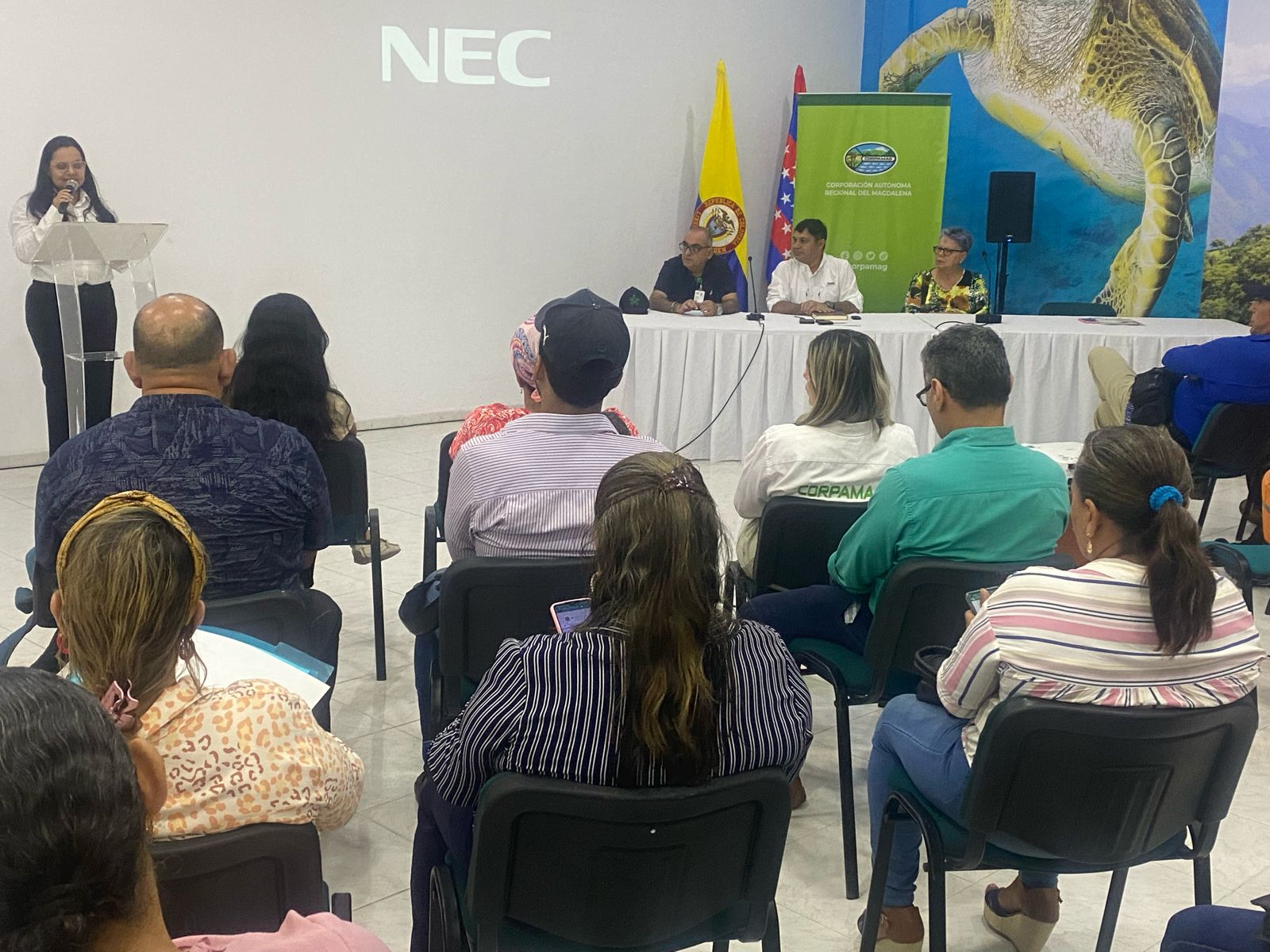 Auditorio con personas y Subdirectora de educacion en el microfono
