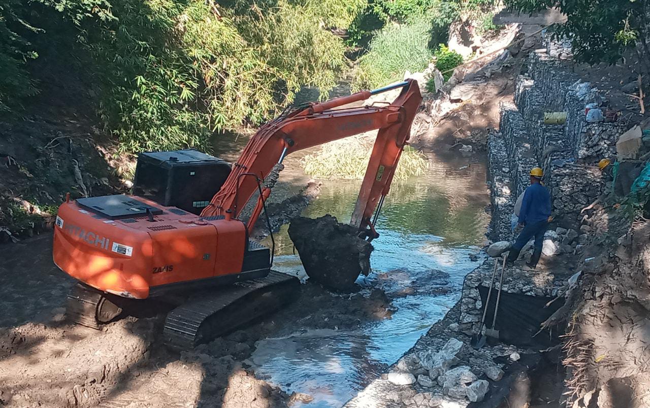 Maquina haciendo limpieza sobre el rio