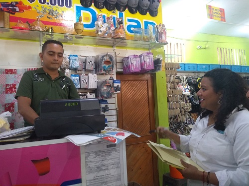 Funcionaria de Corpamag conversa con dueño de establecimiento comercial