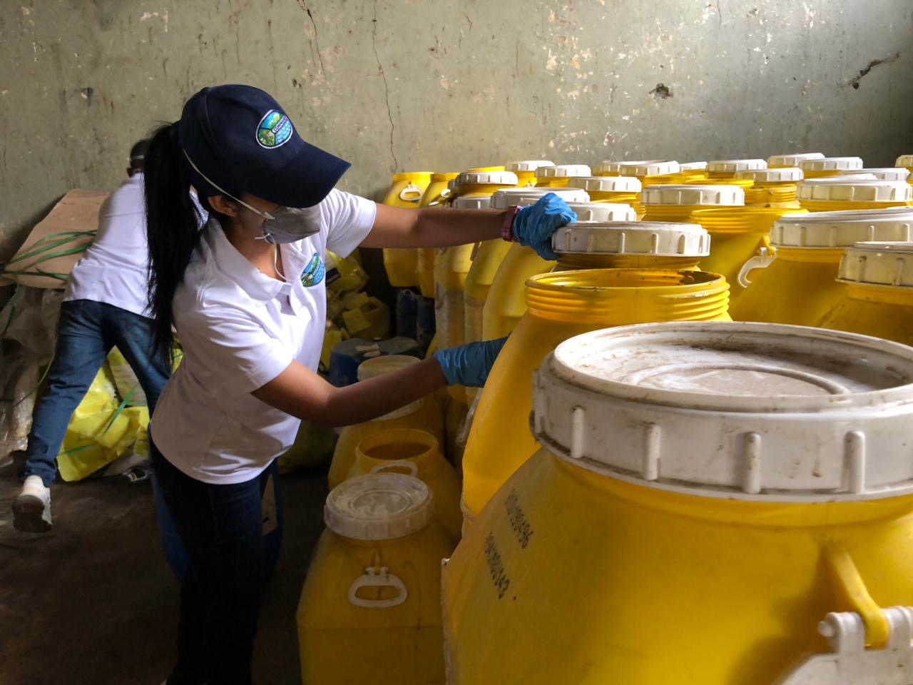 Funcionaria de CORPAMAG tocando con guantes barril amarillo