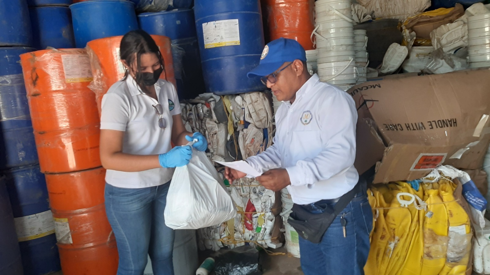 Funcionarios de CORPAMAG sosteniendo bolsa con residuos posconsumo